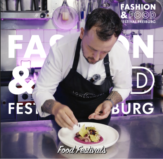 Fashion & Food Festival in Freiburg Koch bei der Zubereitung eines kunstvollen Gerichts auf einem Teller.
